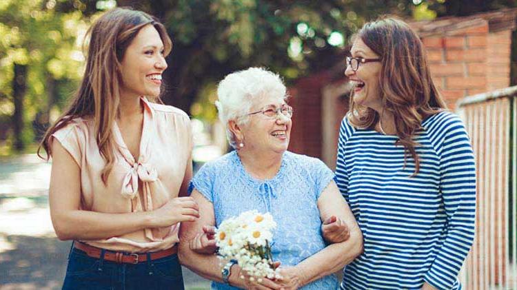 Three generations of women walking and talking about senior 住房选择.