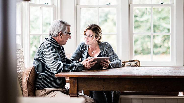 Woman working on a tablet with her father.